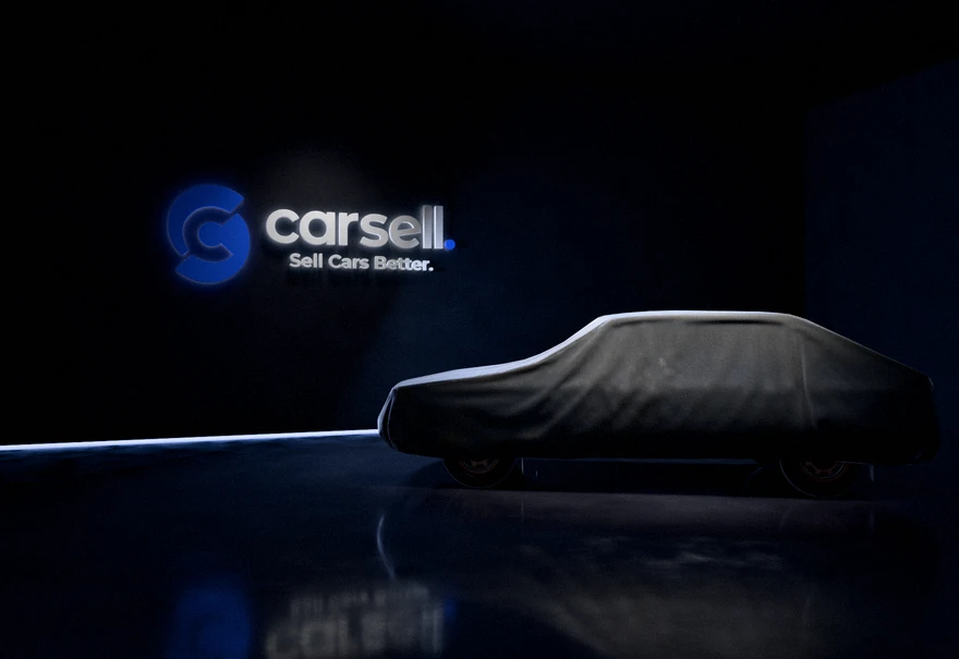 Carsell identity as halo-lit 3D signage in a dark car showroom, with a covered car on a polished floor